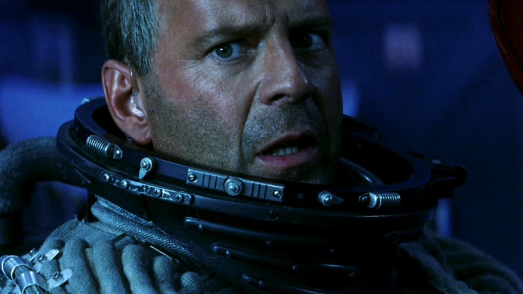 A close-up of Bruce WIllis, wearing a helmetless astronaut suit in Armageddon