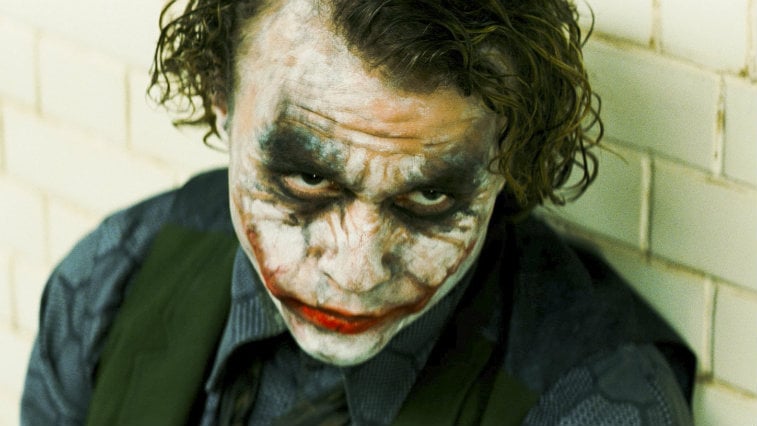 he Joker with some of his makeup off is looking up in The Dark Knight.