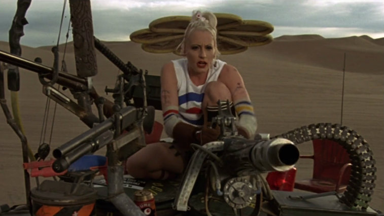 Lori Petty in the desert riding a large machine in Tank Girl
