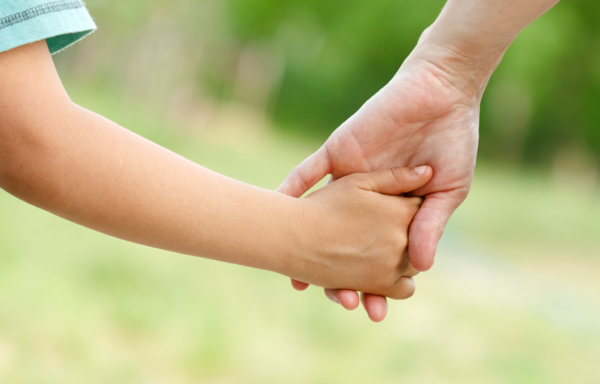 un enfant tenant la main d'un adulte's hand