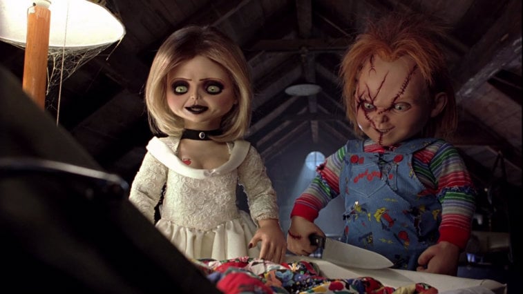 Jennifer Tilly and Chucky sitting at a table. Jennifer Tilly and Chucky sitting at a table.