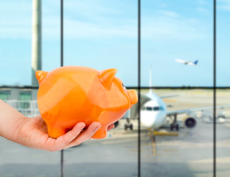 man holding a piggy bank at airport