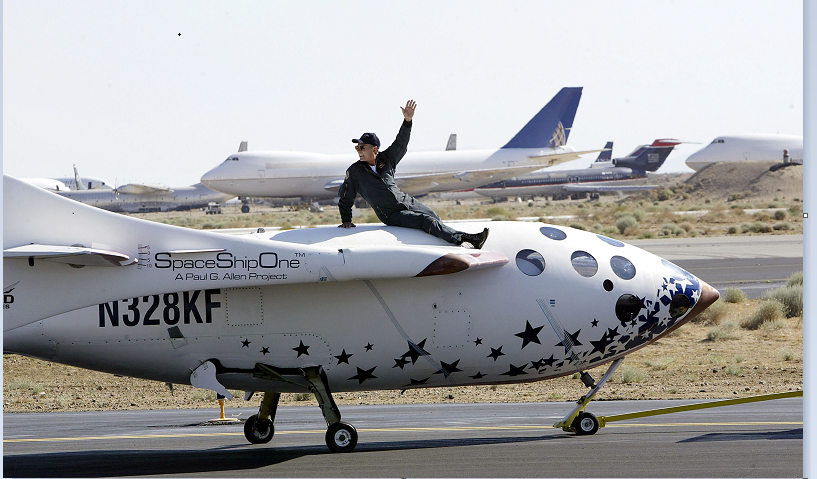 Test pilot Michael Melvill rides atop of SpaceShipOne as it is towed down the runway