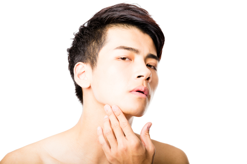attractive young man looking in mirror at sensitive skin