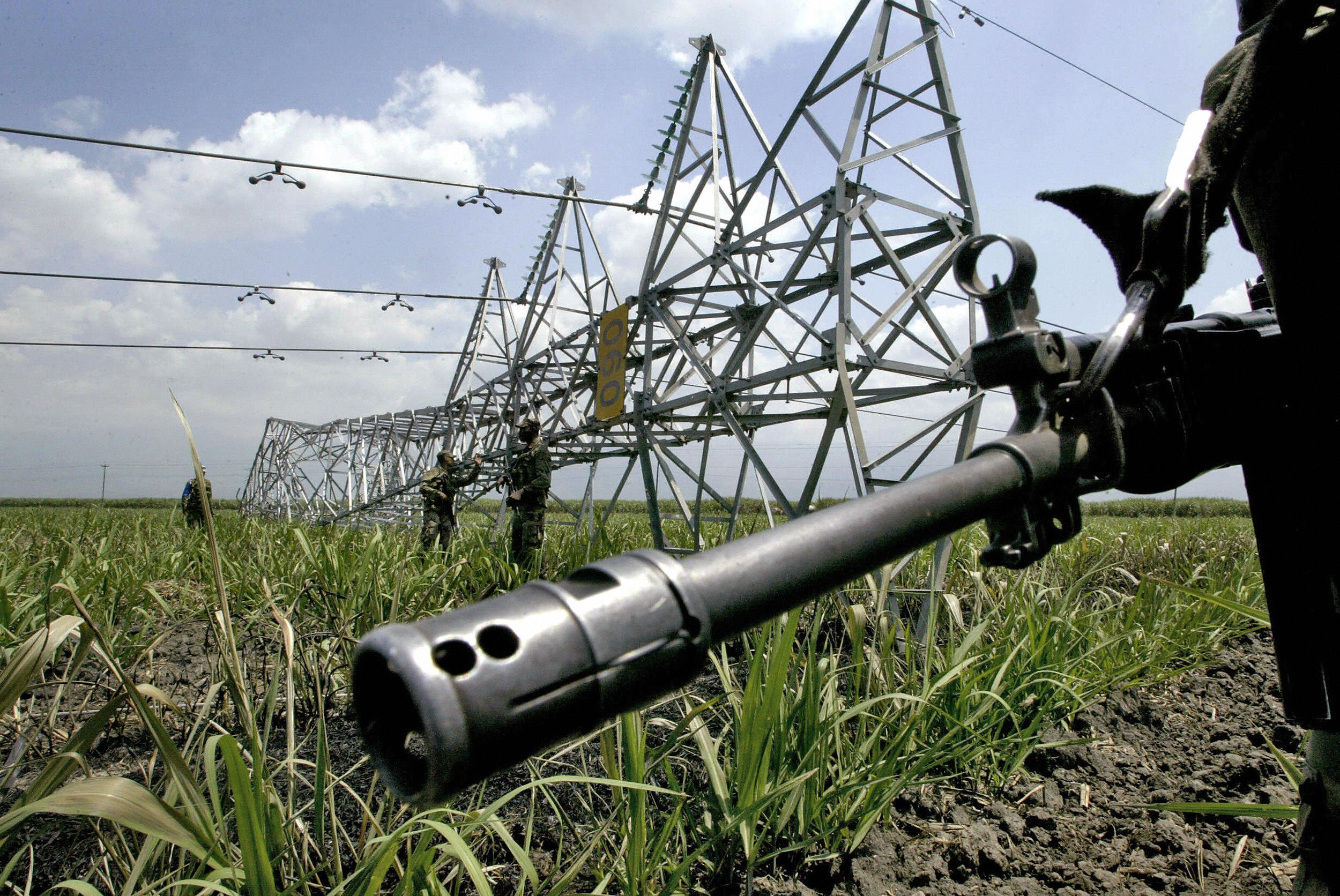 Colombian soldiers guard an electricity tower knocked down during an explosion
