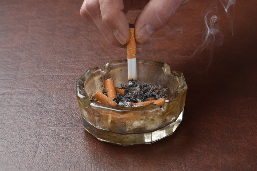 Crushing out a cigarette in a ashtray
