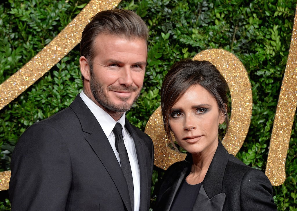 David Beckham and Victoria Beckham pose at an event