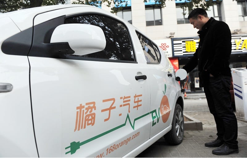This photo taken on March 2, 2016 shows a man charging an electric vehicle at a charging point in Linan, east China's Zhejiang province. Car sales in China jumped nearly nine percent in March from a year earlier, figures from an industry group showed on April 12, a bright spot for the world's second-largest economy. The 14th Beijing International Automotive Exhibition (Auto China 2016) will take place at China International Exhibition Center New Venue (Tianzhu) and China International Exhibition Center Old Venue (Jinganzhuang) simultaneously from April 25 to May 4, 2016. / AFP / STR / China OUT (Photo credit should read STR/AFP/Getty Images)