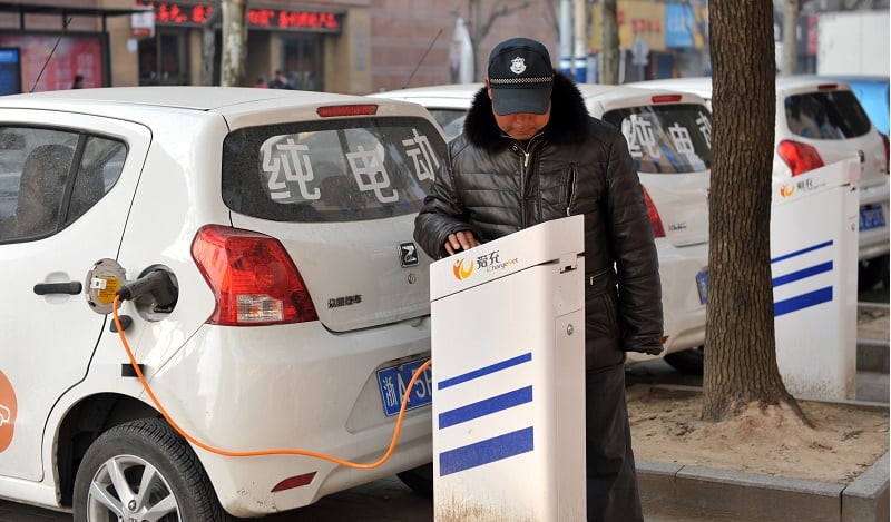 This photo taken on March 2, 2016 shows a man charging an electric vehicle at a charging point in Linan, east China's Zhejiang province. Car sales in China jumped nearly nine percent in March from a year earlier, figures from an industry group showed on April 12, a bright spot for the world's second-largest economy. The 14th Beijing International Automotive Exhibition (Auto China 2016) will take place at China International Exhibition Center New Venue (Tianzhu) and China International Exhibition Center Old Venue (Jinganzhuang) simultaneously from April 25 to May 4, 2016. / AFP / STR / China OUT (Photo credit should read STR/AFP/Getty Images)