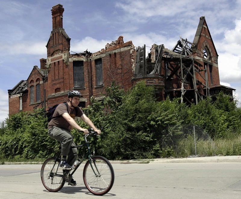 A resident passes an abandoned home in what was once a thriving middle class area in Detroit