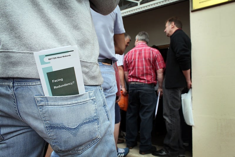 Workers who lost their jobs wait in a queue to find out the details of their redundancy packages at an English factory | Christopher Furlong/Getty Images