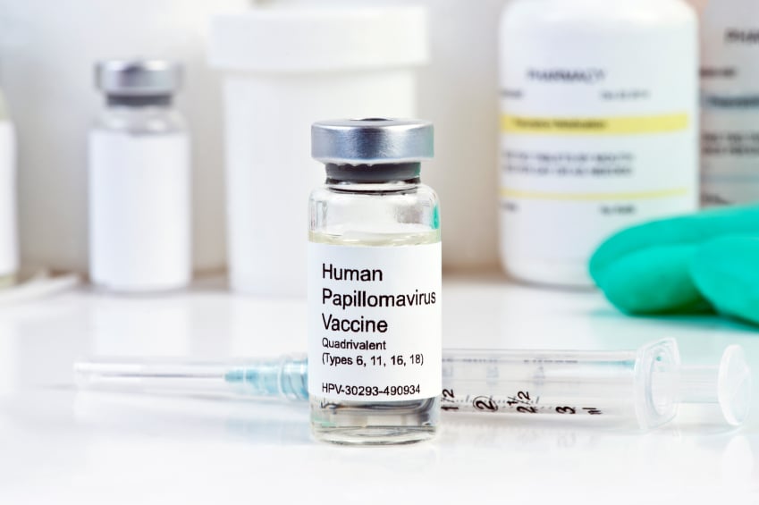 HPV vaccine in a vial next to a syringe