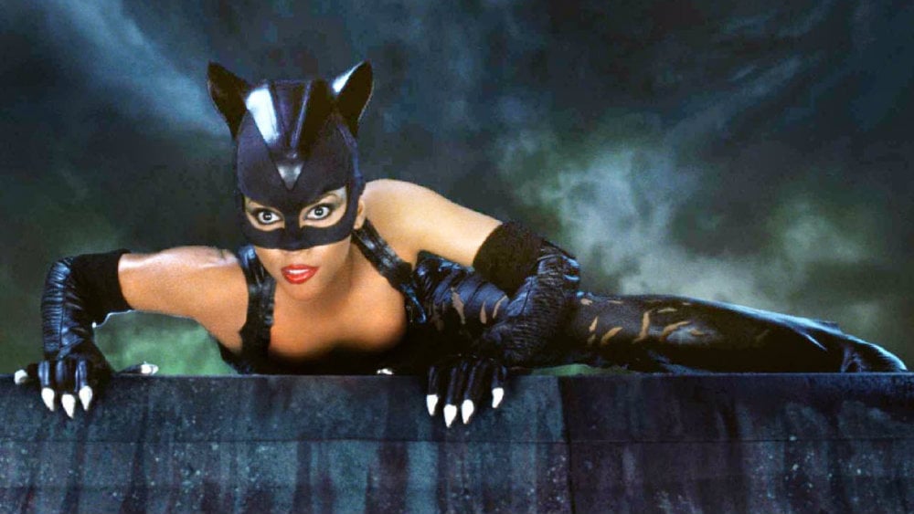 Halle Berry in Catwoman climbing over a wall
