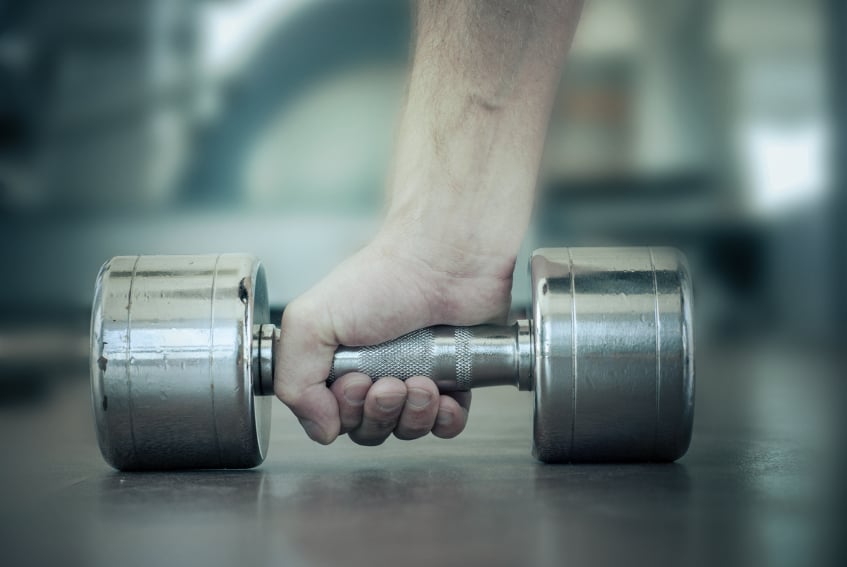 close-up of a man's hand as he chooses a dumbbell