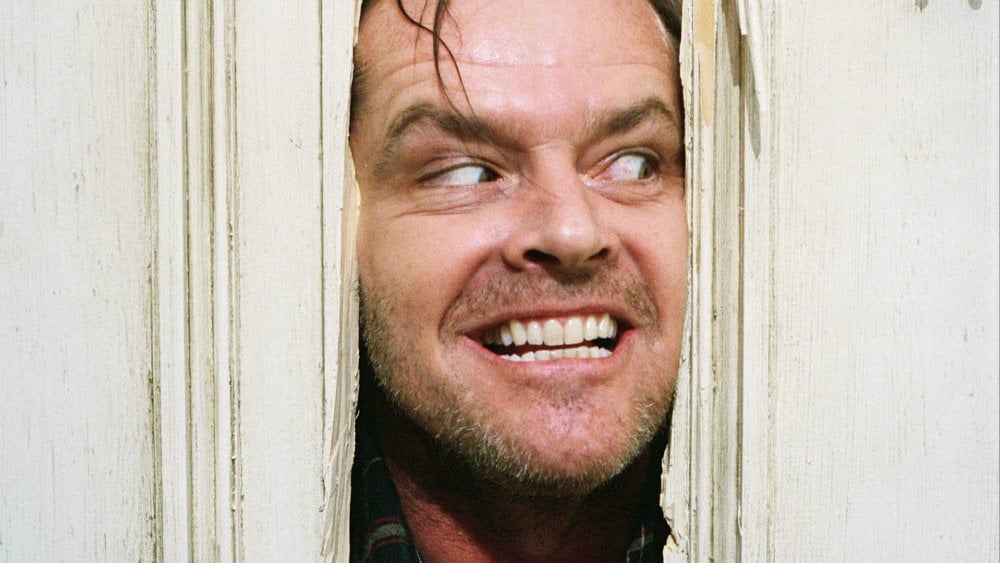 Jack sticks his face in the middle of a crack in a door in The Shining