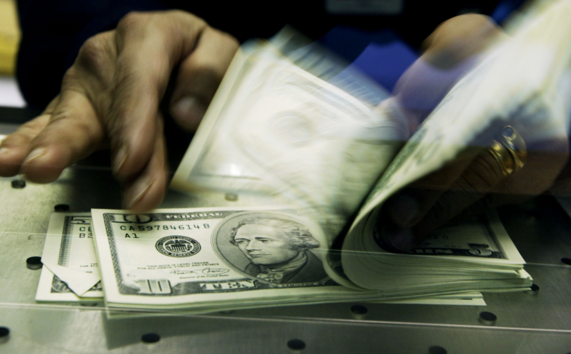 Someone flipping through a stack of money.