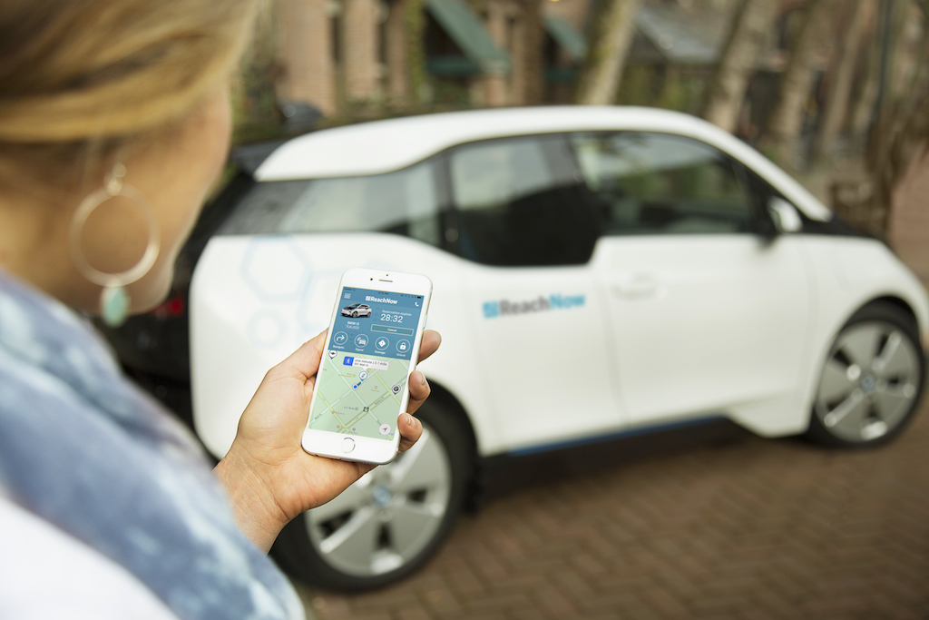 person on phone next to car
