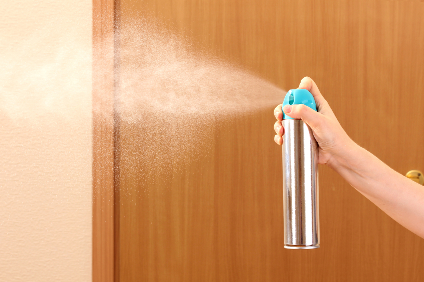 hand spraying through air freshener