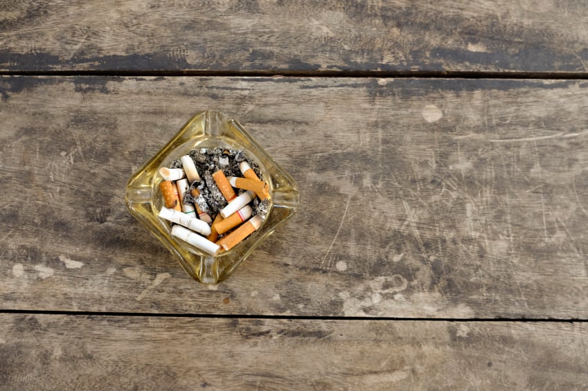 wood deck with an ashtray filled with cigarette butts