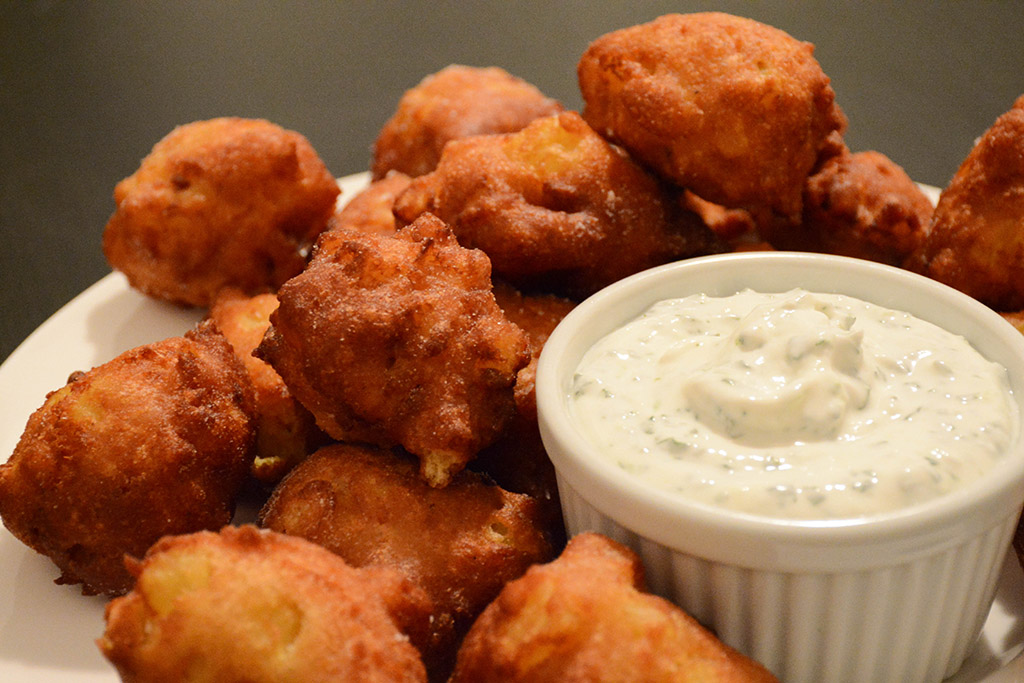 plate filled with curried pineapple fritters served with mint-lime yogurt