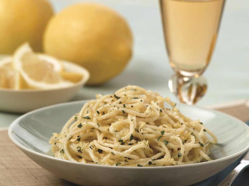 white bowl filled with spaghetti with lemon and basil