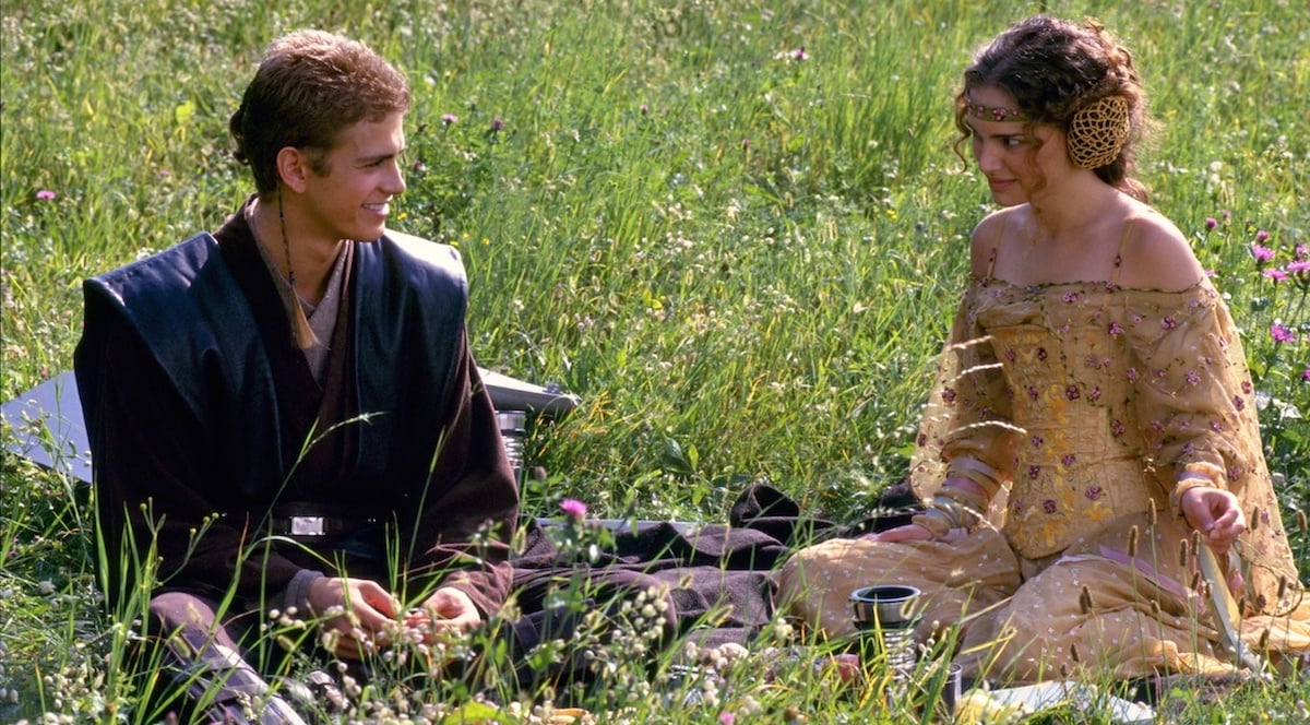 Anakin and Padme talking in a field. 