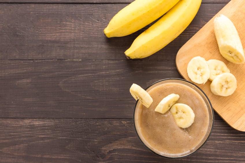 Banana smoothie on wooden background