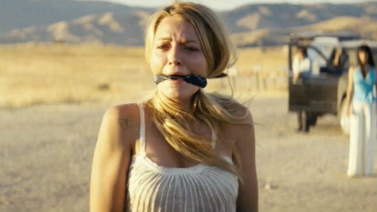Blake Lively is gagged standing in the desert in 'Savages'.