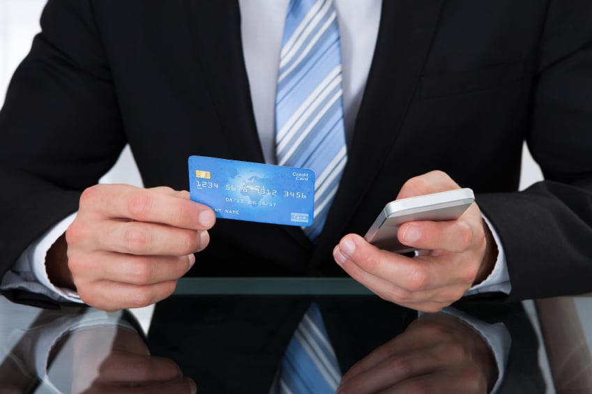 Businessman holding credit card and cell phone