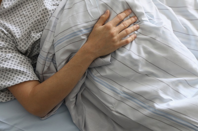A patient lies in a hospital bed
