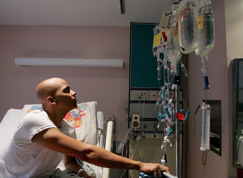 A cancer patient looks at a rack holding bags of chemotherapy while receiving treatment A cancer patient looks at a rack holding bags of chemotherapy while receiving treatment