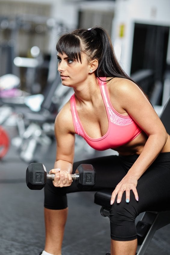 Girl doing biceps in a gym