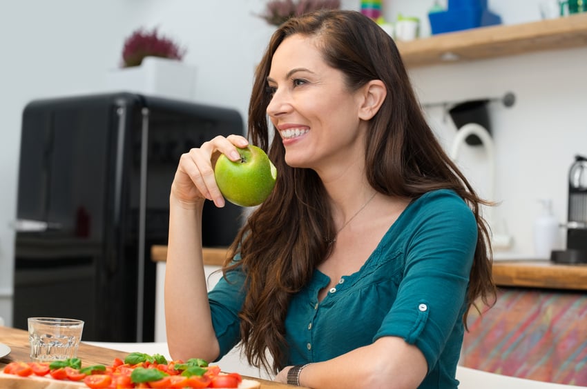 Happy woman eating green apple Happy woman eating green apple