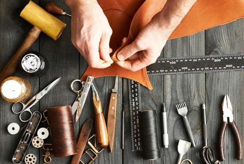 man working on leather with tools