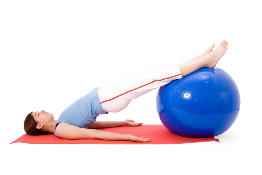 woman performing exercises with fitness ball