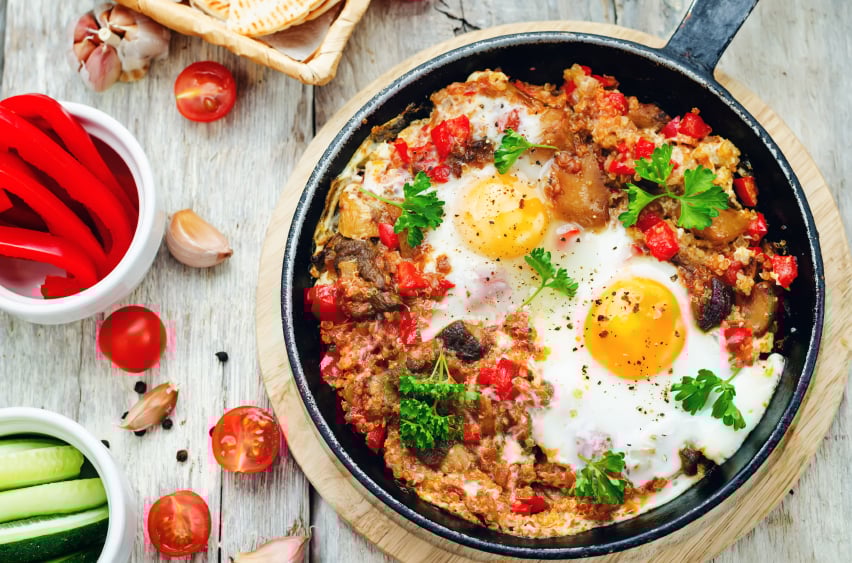 breakfast skillet with quinoa, tomatatoes, peppers, and eggs