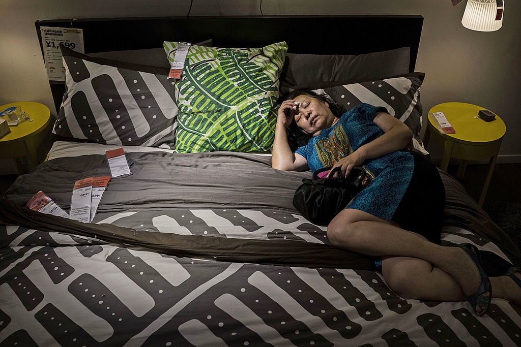 a woman sleeping on an ikea bed