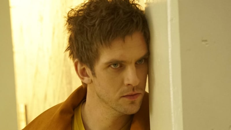 Dan Stevens as David Haller leans against a white wall looking angry in Legion