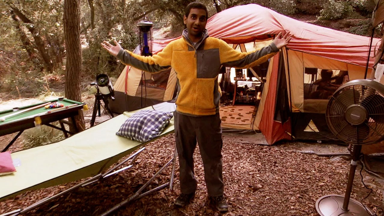 Tom Haverford of "Parks and Recreation" stands in front of several credit purchases