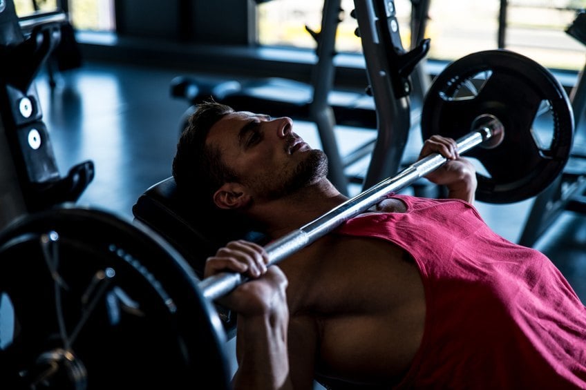 man doing bench press exercise on an incline bench man doing bench press exercise on an incline bench