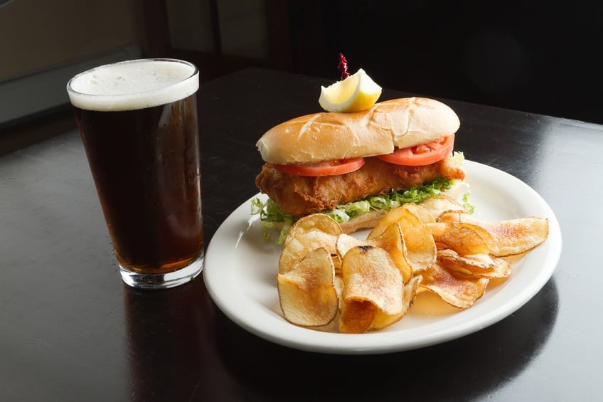 tilapia sandwich with chips and beer