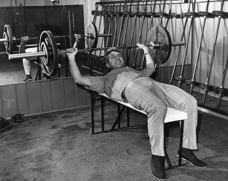 Liberace bodybuilding and building muscle while weight lifting in a gymnasium
