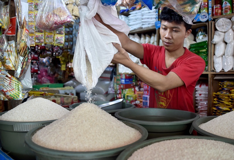 A man dumps rice into a bucket A man dumps rice into a bucket
