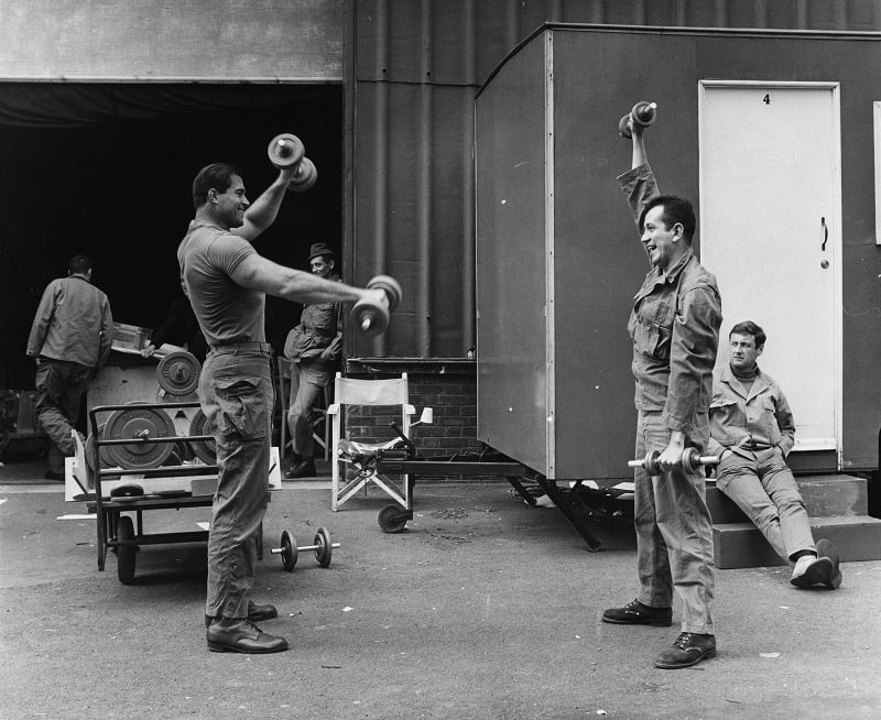 Actors Jim Brown (left) and Trini Lopez, lifting weights and building muscle during the filming of 'The Dirty Dozen'