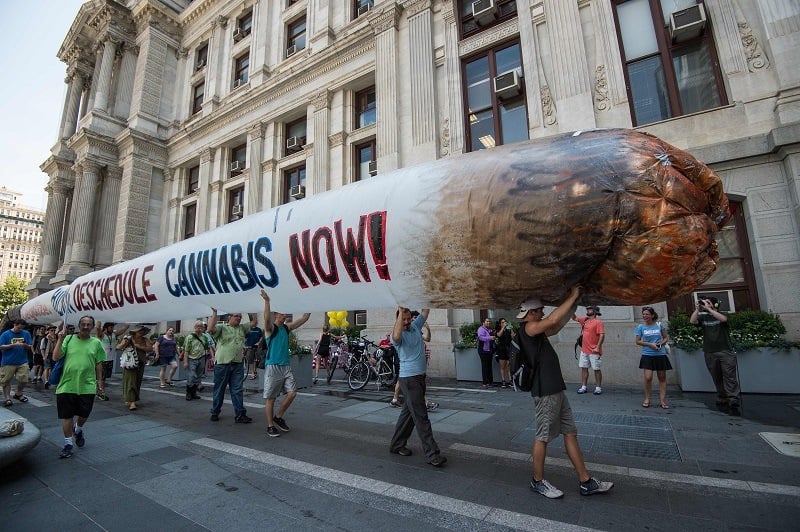Supporters of marijuana legalization hold a giant inflatable joint during a rally