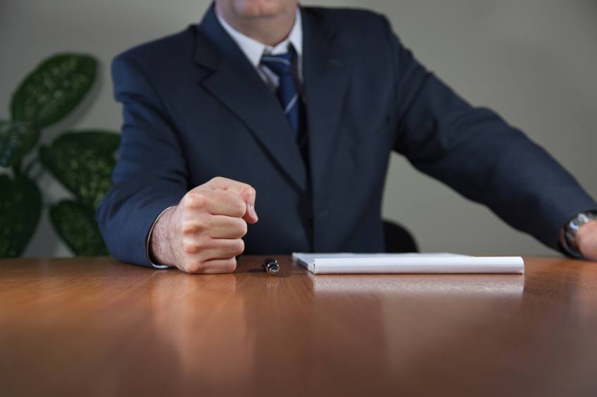 a man in office puts fist on the table