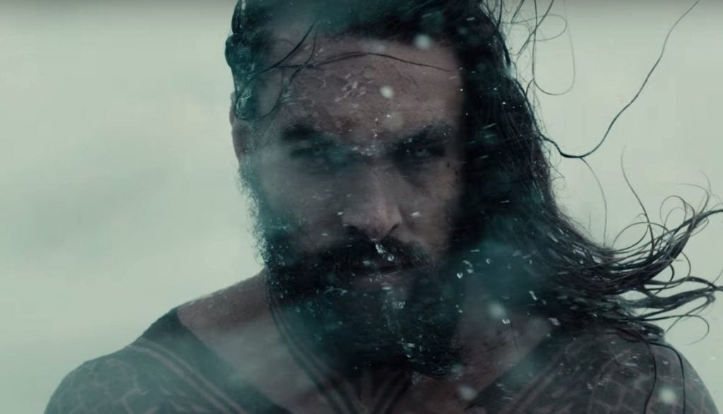 Aquaman stands in the snow looking into the camera