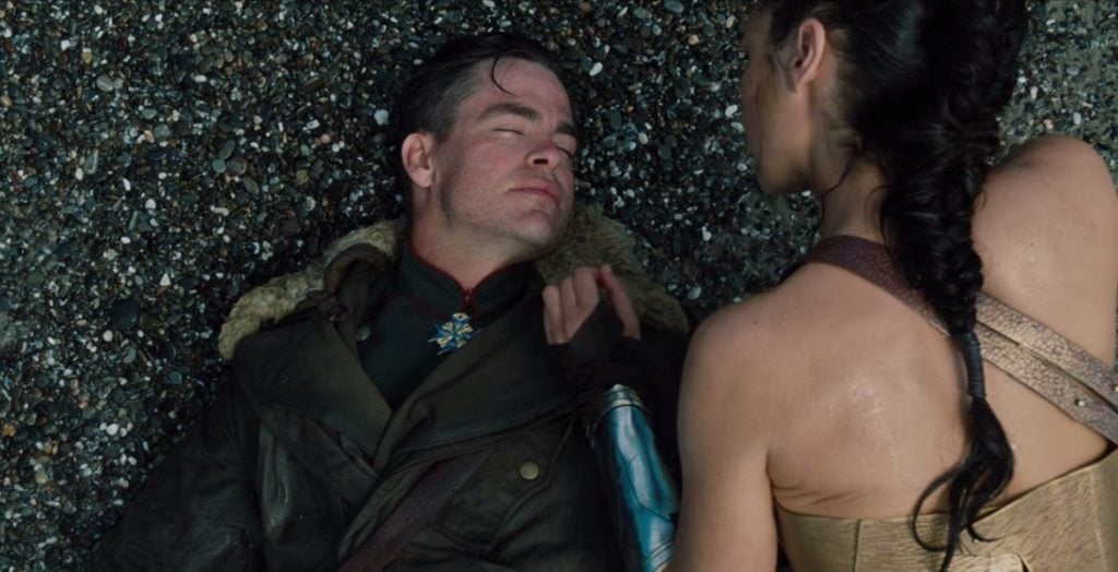 Steve Trevor laying on the beach as Diana hovers over him Steve Trevor laying on the beach as Diana hovers over him