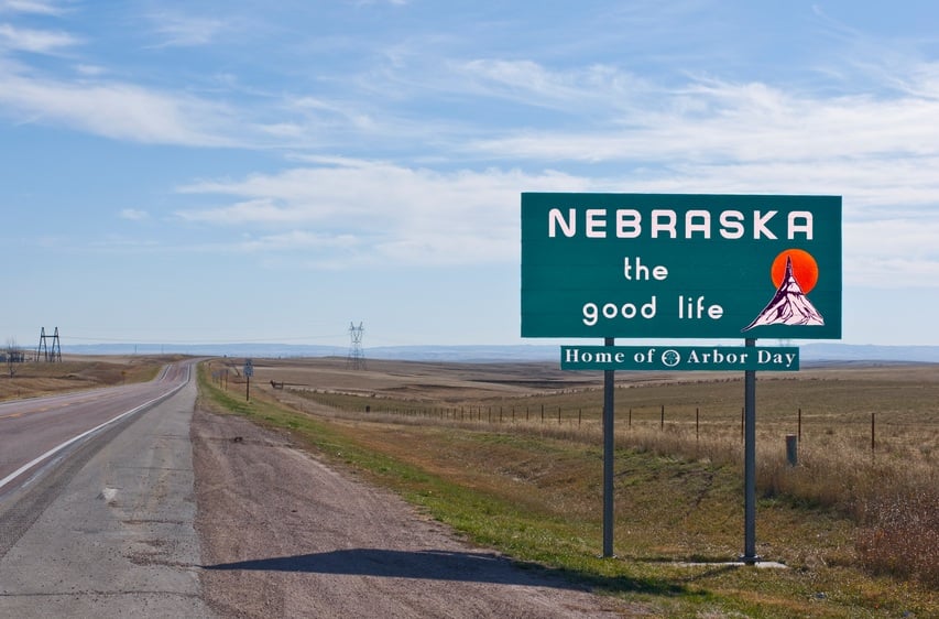 Welcome to Nebraska sign board on a empty road