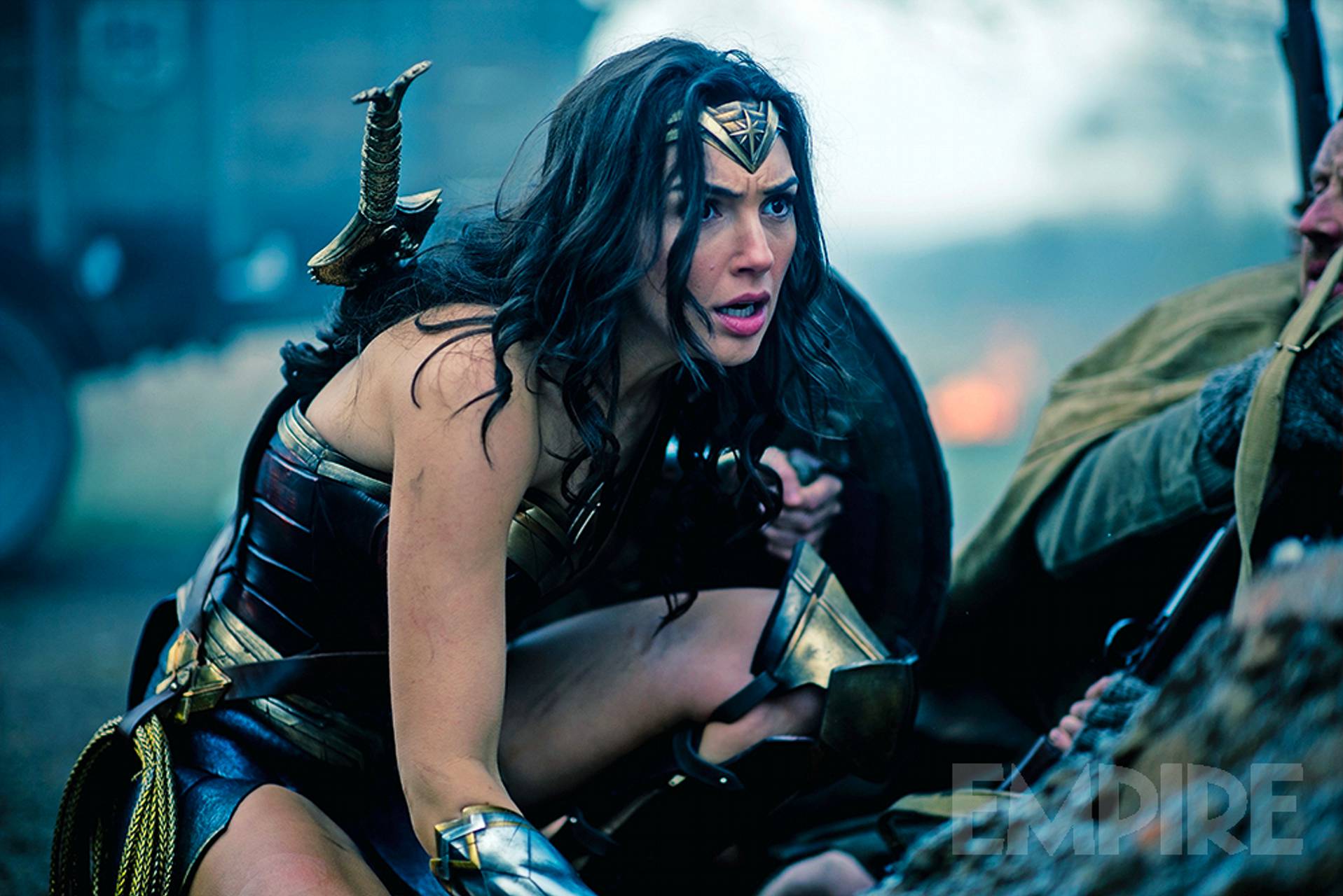 Wonder Woman, played by Gal Gadot, crouching on a battlefield Wonder Woman, played by Gal Gadot, crouching on a battlefield